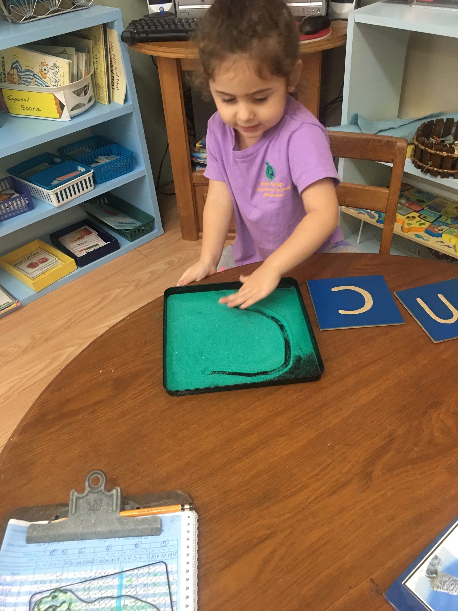 Girl tracing Montessori sandpaper letters