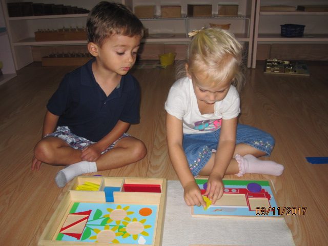 Two toddlers working on a puzzle together in the classroom